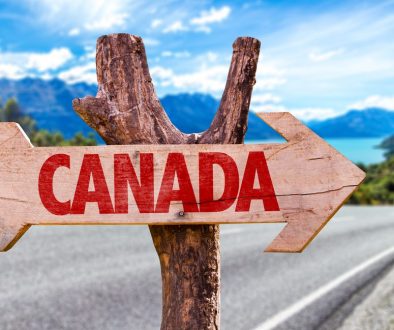 Canada,Wooden,Sign,With,A,Road,Background